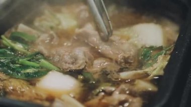 Shabu Shabu veya Sukiyaki veya güveç, domuz restoranında Japon yemekleri yemek çubukları, kullanarak tutan el