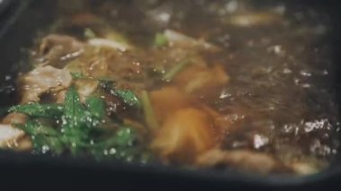 Shabu Shabu veya Sukiyaki veya güveç, domuz restoranında Japon yemekleri yemek çubukları, kullanarak tutan el