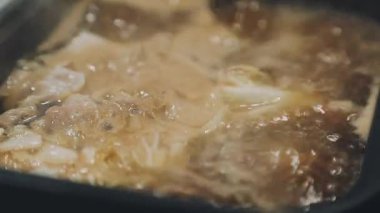 Shabu Shabu veya Sukiyaki veya güveç, domuz restoranında Japon yemekleri yemek çubukları, kullanarak tutan el