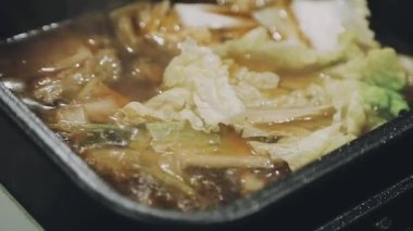 Shabu Shabu veya Sukiyaki veya güveç, domuz restoranında Japon yemekleri yemek çubukları, kullanarak tutan el