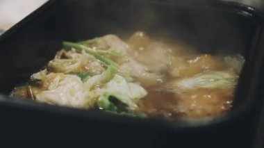 Shabu Shabu veya Sukiyaki veya güveç, domuz restoranında Japon yemekleri yemek çubukları, kullanarak tutan el