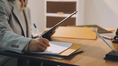 Adalet ve hukuk kavramı. Gavel, mahkeme salonundaki erkek hakim hakkında, evrak hukuku kitaplarıyla çalışıyor, davayı modern bürodaki masada rapor ediyor..