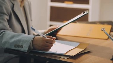 Adalet ve hukuk kavramı. Gavel, mahkeme salonundaki erkek hakim hakkında, evrak hukuku kitaplarıyla çalışıyor, davayı modern bürodaki masada rapor ediyor..