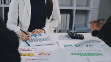 İki İşadamı İşyerinde Hesap Makinesini kullanarak Faturaları Hesaplıyor. İş ekibi toplantısı ve proje planı. İş adamları toplantı odasında tartışıyor..