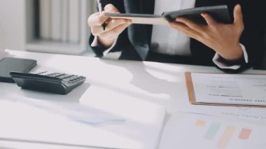 İki İşadamı İşyerinde Hesap Makinesini kullanarak Faturaları Hesaplıyor. İş ekibi toplantısı ve proje planı. İş adamları toplantı odasında tartışıyor..