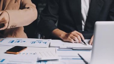 İki İşadamı İşyerinde Hesap Makinesini kullanarak Faturaları Hesaplıyor. İş ekibi toplantısı ve proje planı. İş adamları toplantı odasında tartışıyor..