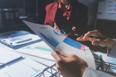 İş adamları ya da muhasebeciler, iş yeri, muhasebe kavramı üzerine analitik iş raporları hazırlarken hesap makinesi kullanırlar.,