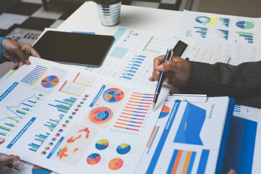 Ofiste çalışan denetçi ve muhasebeci ekibi mali verileri ve muhasebe kayıtlarını hesap makinesiyle analiz ediyor. Muhasebe şirketi kârlı nakit akışı için finansman ve vergilendirme planlaması sağlıyor.