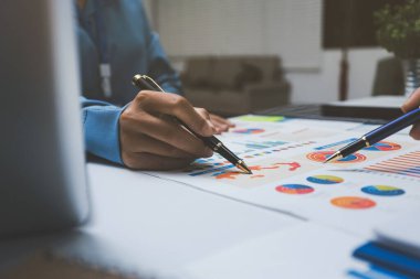 Ofiste çalışan denetçi ve muhasebeci ekibi mali verileri ve muhasebe kayıtlarını hesap makinesiyle analiz ediyor. Muhasebe şirketi kârlı nakit akışı için finansman ve vergilendirme planlaması sağlıyor.