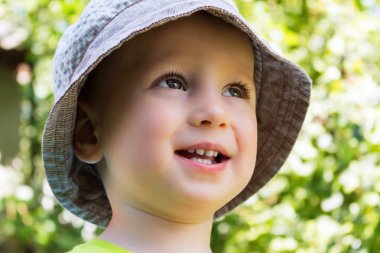 Yaz şapka, ormanın içinde gülümseyen güzel çocuk portresi