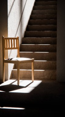 3 boyutlu ahşap sandalye, dramatik güneş ışığı ve gölgeli merdiven tabanında. Minimalist tarzda iç tasarım, ürün gösterimi ve mimari görselleştirme için ideal.