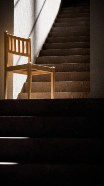 3 boyutlu ahşap sandalye, dramatik güneş ışığı ve gölgeli merdiven tabanında. Minimalist tarzda iç tasarım, ürün gösterimi ve mimari görselleştirme için ideal.