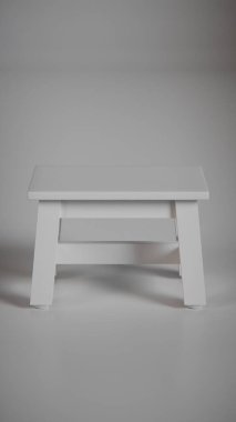 Üç boyutlu minimalist tahta tabure, sağlam çerçeveli ve açılı bacakları var. Mobilya katalogları, ürün görselleştirme, iç tasarım projeleri ve modern dekor sunumları için mükemmel..