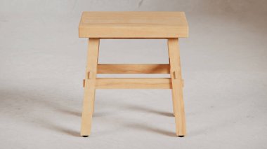 Üç boyutlu minimalist tahta tabure, açılı bacaklar, destek kirişleri ve pürüzsüz bitiş. Mobilya katalogları, ürün görselleştirme, iç tasarım projeleri ve modern dekor sunumları için mükemmel..