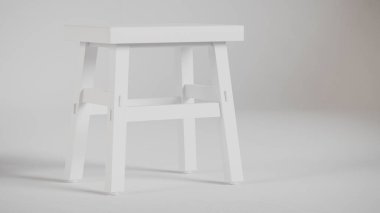 Üç boyutlu minimalist tahta tabure, açılı bacaklar, destek kirişleri ve pürüzsüz bitiş. Mobilya katalogları, ürün görselleştirme, iç tasarım projeleri ve modern dekor sunumları için mükemmel..