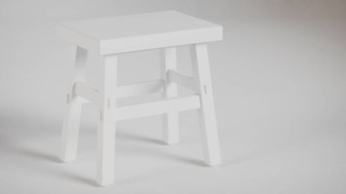 Üç boyutlu minimalist tahta tabure, açılı bacaklar, destek kirişleri ve pürüzsüz bitiş. Mobilya katalogları, ürün görselleştirme, iç tasarım projeleri ve modern dekor sunumları için mükemmel..