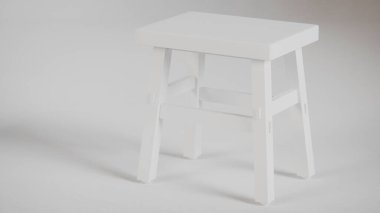 Üç boyutlu minimalist tahta tabure, açılı bacaklar, destek kirişleri ve pürüzsüz bitiş. Mobilya katalogları, ürün görselleştirme, iç tasarım projeleri ve modern dekor sunumları için mükemmel..