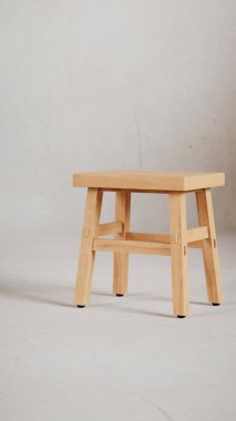 Üç boyutlu minimalist tahta tabure, açılı bacaklar, destek kirişleri ve pürüzsüz bitiş. Mobilya katalogları, ürün görselleştirme, iç tasarım projeleri ve modern dekor sunumları için mükemmel..