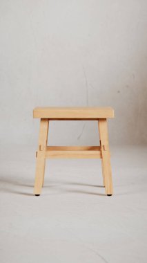 Üç boyutlu minimalist tahta tabure, açılı bacaklar, destek kirişleri ve pürüzsüz bitiş. Mobilya katalogları, ürün görselleştirme, iç tasarım projeleri ve modern dekor sunumları için mükemmel..