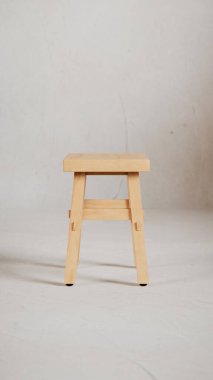 Üç boyutlu minimalist tahta tabure, açılı bacaklar, destek kirişleri ve pürüzsüz bitiş. Mobilya katalogları, ürün görselleştirme, iç tasarım projeleri ve modern dekor sunumları için mükemmel..