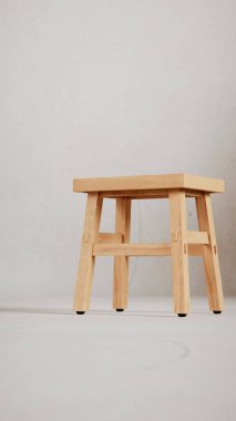 Üç boyutlu minimalist tahta tabure, açılı bacaklar, destek kirişleri ve pürüzsüz bitiş. Mobilya katalogları, ürün görselleştirme, iç tasarım projeleri ve modern dekor sunumları için mükemmel..