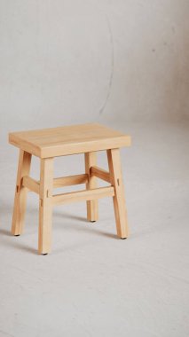 Üç boyutlu minimalist tahta tabure, açılı bacaklar, destek kirişleri ve pürüzsüz bitiş. Mobilya katalogları, ürün görselleştirme, iç tasarım projeleri ve modern dekor sunumları için mükemmel..