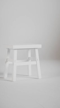 Üç boyutlu minimalist tahta tabure, açılı bacaklar, destek kirişleri ve pürüzsüz bitiş. Mobilya katalogları, ürün görselleştirme, iç tasarım projeleri ve modern dekor sunumları için mükemmel..