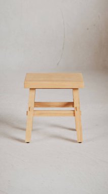 Üç boyutlu minimalist tahta tabure, açılı bacaklar, destek kirişleri ve pürüzsüz bitiş. Mobilya katalogları, ürün görselleştirme, iç tasarım projeleri ve modern dekor sunumları için mükemmel..