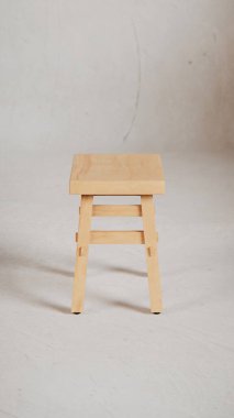 Üç boyutlu minimalist tahta tabure, açılı bacaklar, destek kirişleri ve pürüzsüz bitiş. Mobilya katalogları, ürün görselleştirme, iç tasarım projeleri ve modern dekor sunumları için mükemmel..