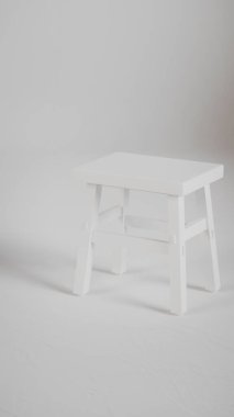 Üç boyutlu minimalist tahta tabure, açılı bacaklar, destek kirişleri ve pürüzsüz bitiş. Mobilya katalogları, ürün görselleştirme, iç tasarım projeleri ve modern dekor sunumları için mükemmel..