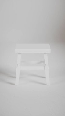 Üç boyutlu minimalist tahta tabure, açılı bacaklar, destek kirişleri ve pürüzsüz bitiş. Mobilya katalogları, ürün görselleştirme, iç tasarım projeleri ve modern dekor sunumları için mükemmel..