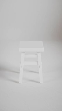 Üç boyutlu minimalist tahta tabure, açılı bacaklar, destek kirişleri ve pürüzsüz bitiş. Mobilya katalogları, ürün görselleştirme, iç tasarım projeleri ve modern dekor sunumları için mükemmel..