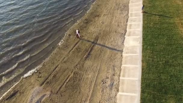 Ζεύγος που περπατά στην παραλία το ηλιοβασίλεμα. Σκοποβολή με quadrocopters. Dron. Dji phantom — Αρχείο Βίντεο