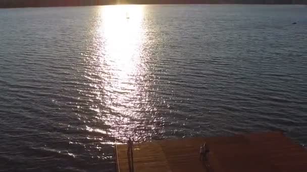 Ζευγάρι staing στην αποβάθρα στο ηλιοβασίλεμα. Σκοποβολή με quadrocopters. Dron. Dji phantom — Αρχείο Βίντεο