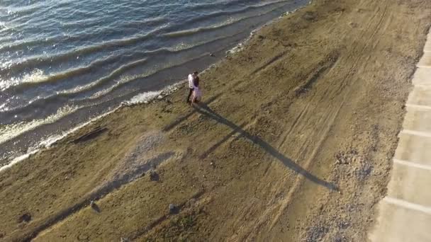 Pareja caminando por la playa al atardecer. Disparando con quadrocopters. ¡Dron! Dji Phantom — Vídeos de Stock