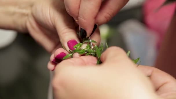Womens hands weave a wreath with a needle and thread, the process of weaving wreaths — Stockvideo