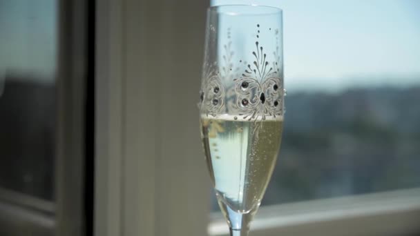 Two rings fall into a glass of champagne, making sparkling bubbles. — Wideo stockowe