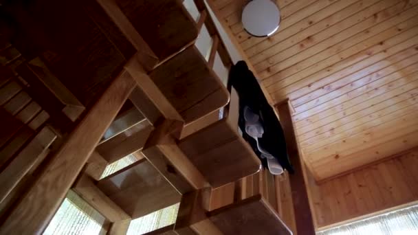 Mens suit on a hanger hanging on the wooden stairs of a two-story house — Stock Video