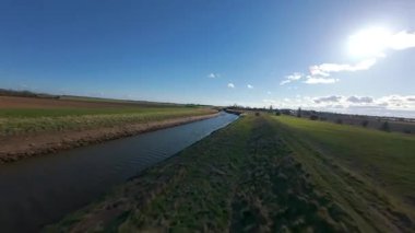 FPV insansız hava aracı, kırsal tarım arazileri ve tarlaların üzerinden uçuyor, sel bankaları ve sulak bataklık bölgeleri, Hughnshire, İngiltere, İngiltere, güneşli bahar günü 