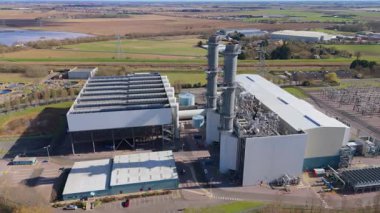 Büyük enerji santralinin hava aracı görüntüsü, fosil yakıt, gaz ve petrol kömürü üreten istasyon, duman yığınları ve baca, kontrol odası ve sütunlar ve sanayi binaları, alt istasyon elektrik hatları, Spalding, Birleşik Krallık 