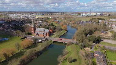 İngiltere 'nin doğusunda, Fens' te, güneşli bir bahar gününde Spalding 'de nehir kıyısındaki büyük kilise katedralinin havadan manzarası.