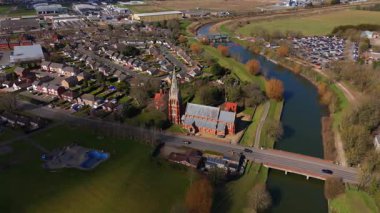 İngiltere 'nin doğusunda, Fens' te, güneşli bir bahar gününde Spalding 'de nehir kıyısındaki büyük kilise katedralinin havadan manzarası.