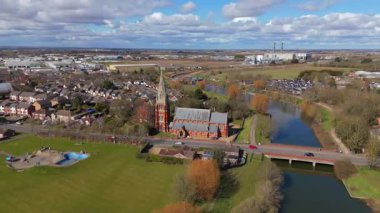 İngiltere 'nin doğusunda, Fens' te, güneşli bir bahar gününde Spalding 'de nehir kıyısındaki büyük kilise katedralinin havadan manzarası.