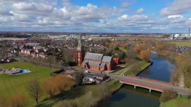 İngiltere 'nin doğusunda, Fens' te, güneşli bir bahar gününde Spalding 'de nehir kıyısındaki büyük kilise katedralinin havadan manzarası.