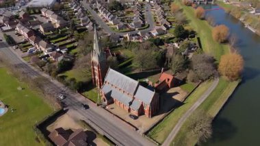 İngiltere 'nin doğusunda, Fens' te, güneşli bir bahar gününde Spalding 'de nehir kıyısındaki büyük kilise katedralinin havadan manzarası.