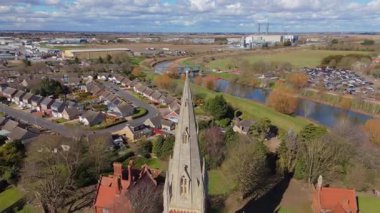 İngiltere 'nin doğusunda, Fens' te, güneşli bir bahar gününde Spalding 'de nehir kıyısındaki büyük kilise katedralinin havadan manzarası.