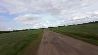 FPV insansız hava aracı kırsal alanda yerin üzerinde uçuyor. yüksek hızlı yarış dronu. 