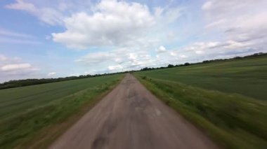 FPV insansız hava aracı kırsal alanda yerin üzerinde uçuyor. yüksek hızlı yarış dronu. 