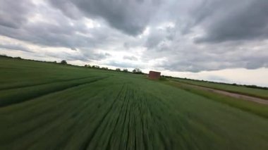 FPV insansız hava aracı kırsal alanda yerin üzerinde uçuyor. yüksek hızlı yarış dronu. 