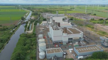 Dev elektrik santrali, elektrik santrali elektrik üretimi, elektrik direkleri ve rüzgar türbinli alt istasyonların havadan görüntüsü 